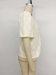 Detail of white lace short sleeve top with diamond hollow embroidery and scalloped edges