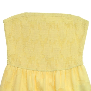 Détail du tissu jacquard floral jaune avec une texture smockée élastique élégante