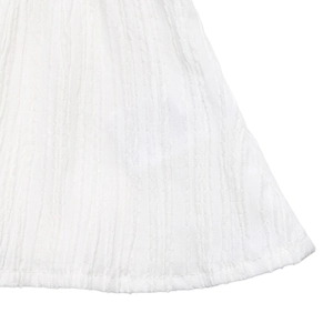 Close-up detail of white blouse hem showing vertical pleated texture and neat stitching