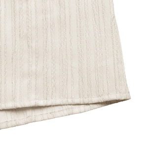 Close-up of white summer dress fabric showing vertical texture and dual stitching