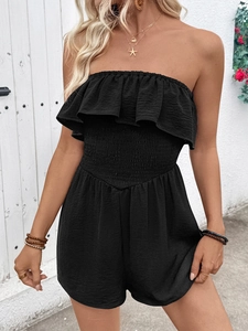 Detail of black strapless romper with ruffled neckline and smocked high waist texture