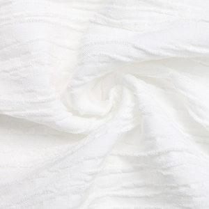 Detailed macro shot of white fabric with textured pleats and soft wave pattern