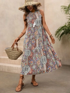 Détail d'une robe longue bohème sans manches avec imprimé paisley et cordon à glands