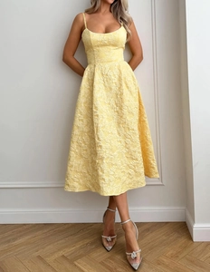 Detail of light yellow jacquard maxi dress with spaghetti straps and textured floral fabric