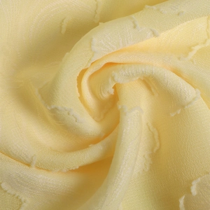 Vue détaillée du tissu jacquard jaune pâle semi-transparent avec texture ondulée et franges