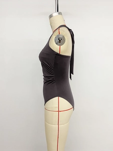 Detail of dark gray halter bodysuit featuring ruched sides and adjustable back ties