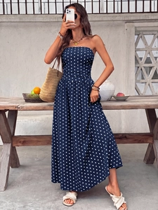 Detail view of navy blue polka dot strapless maxi dress with smocked waist and A-line skirt