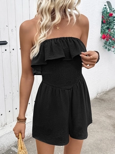 Detail of smocked elastic waist and ruffled neckline on black strapless romper