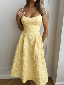 Detailed close-up of light yellow jacquard fabric texture on elegant strap dress