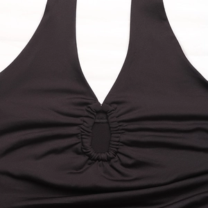 Detail of black halter neck bodysuit showing keyhole cutout and ruched fabric texture