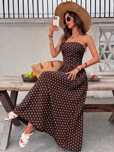 Detail of elegant coffee brown polka dot strapless summer maxi dress in soft light