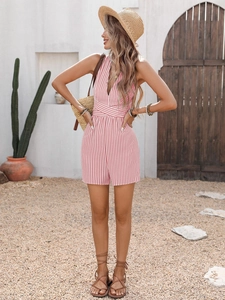 Macro detail of pink striped romper featuring a deep V-neck and crisscross waist design