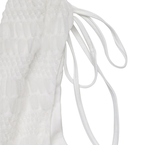 Close-up of white smocked fabric texture and thin straps on a summer vacation dress