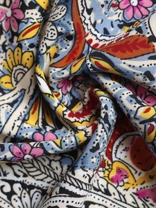 Gros plan sur un tissu imprimé floral bohème avec motifs roses et jaunes complexes