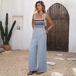 Detail of colorful geometric embroidery on the chest of a light blue bohemian jumpsuit
