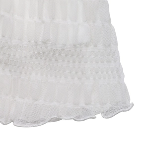 Detailed macro view of white pleated fabric with delicate ruffled hem and mesh texture
