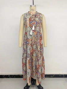 Détail d'une robe longue bohème à col en V avec cordons à pompons et motifs paisley