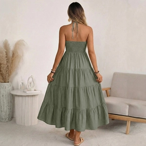 Back view of a sage green halter neck maxi dress with smocked detailing and tiered skirt