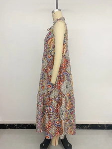 Détail d'une robe longue bohème avec motifs paisley colorés et jupe à franges à plusieurs niveaux