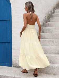Détail d'une robe maxi crème dos nu avec attaches licou et taille élastique froncée