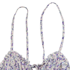 Detail of floral spaghetti strap top with ruffle neckline and tie-up bow detail