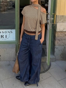 Détail du haut asymétrique rayé avec encolure licou et pantalon en denim large
