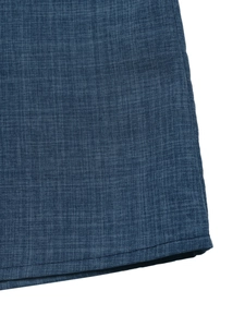 Macro de la texture du tissu bleu foncé et de l'ourlet piqué du combishort d'été
