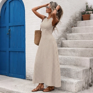 Détail d'une élégante robe longue trapèze sans manches à pois beige et col rond