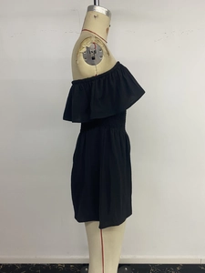 Side view detail of a black off-shoulder romper featuring ruffled neckline and elastic waist