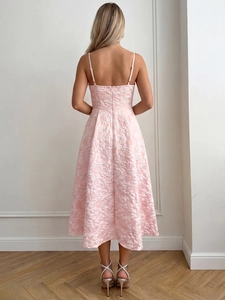 Vue arrière d'une robe midi en jacquard rose pâle avec fines bretelles et dos nu