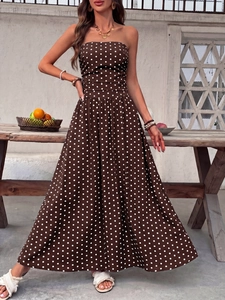 Detail of a brown strapless polka dot maxi dress featuring a shirred waist and flowing hem
