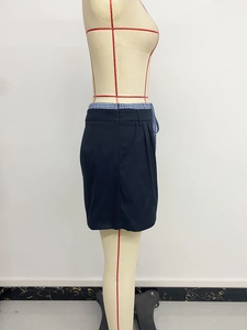 Detail of the black A-line skirt featuring side pockets and plaid interior lining