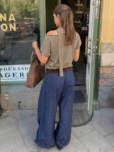 Détail du haut rayé à épaules dénudées avec ruban et pantalon large à cordon bleu