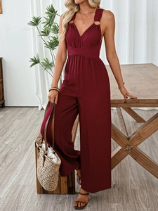 Detail of burgundy halter jumpsuit with deep V-neck and golden ring strap accents