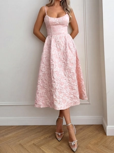 Détail du tissu jacquard floral rose clair sur l'élégante robe midi dos nu