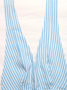 Detail of blue and white striped fabric showing V-neck tailoring and thin shoulder straps