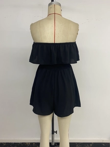 Back view of black strapless romper with layered ruffles and elastic shirred waist