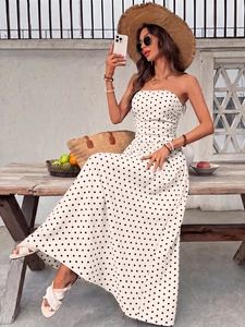 Detail of elegant strapless polka dot maxi dress featuring gathered waist and airy fabric