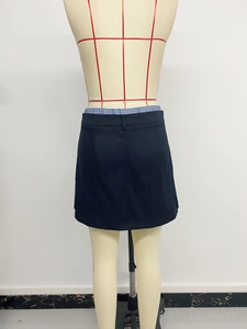 Detail view of the back of a slim fit mini skirt featuring blue plaid fabric patchwork