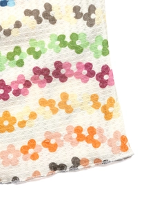 Détail du tissu gaufré blanc avec imprimé floral coloré et bordure en vagues douces