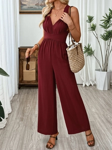 Detail view of wine red V-neck sleeveless jumpsuit featuring high waist and buckle belt