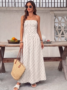 Chic strapless polka dot maxi dress styled with a straw bag for summer vacation