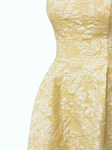 Close-up of elegant yellow floral jacquard fabric with waist tailoring and texture details