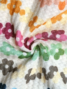 Gros plan sur un tissu gaufré doux avec imprimé floral et texture de tricot