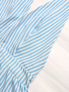 Close-up of blue and white striped fabric texture and clean stitching of the romper