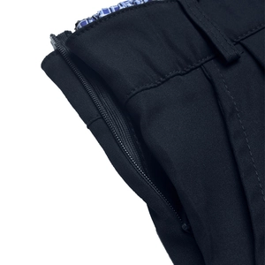 Detail view of smooth zipper closure and plaid lining on high-waisted navy skirt