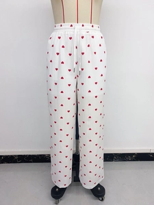 Dettaglio dei pantaloni estivi bianchi con stampa a cuori rossi e vita con coulisse