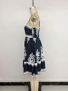 Detail view of the navy blue sleeveless dress featuring white ethnic print and A-line hem