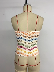 Détails du dos d'un top court avec des motifs floraux en paillettes colorées et textures