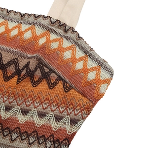 Detailaufnahme des böhmischen Wellen-Häkelmusters in Orange- und Brauntönen der Hose